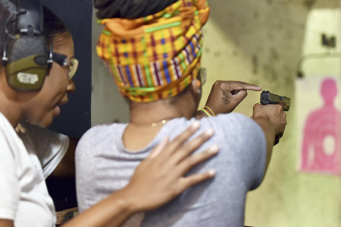 In this May 27, 2017, photo, Marchelle Tigner, a firearms instructor, teaches a student how to shoot a gun during a class in Lawrenceville, Ga. Tigner's goal is to train 1 million women how to shoot a gun in her lifetime. She is among the nation's black women gun owners who say they are picking up firearms for self-protection.
