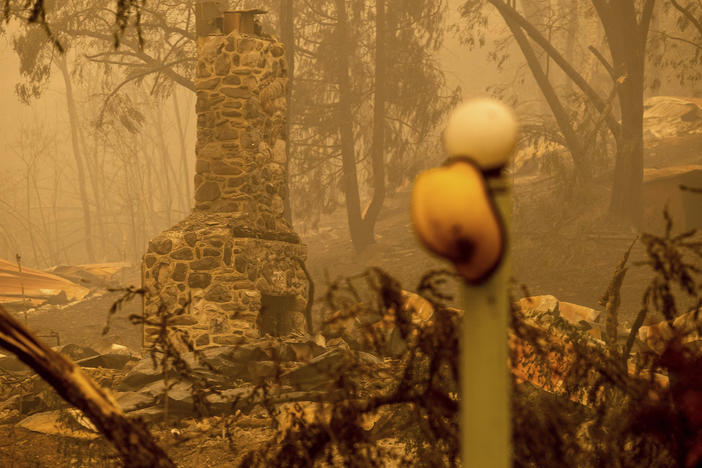 A chimney stands at a destroyed building as the McKinney Fire burns in Klamath National Forest, Calif., on Sunday.