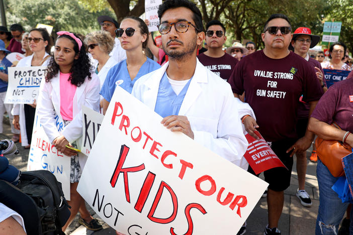 Sharwin Khot holding a sign stating, "Protect our kids not gun" during the rally in Austin to demand age increase for AR-15 sales.