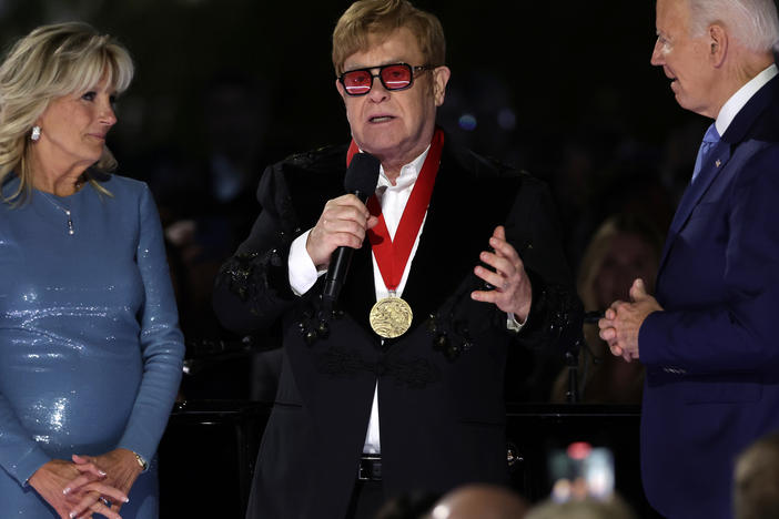 Sir Elton John speaks after being presented with the National Humanities Medal by President Biden as first lady Jill Biden looks on during an event at the South Lawn of the White House on Friday.