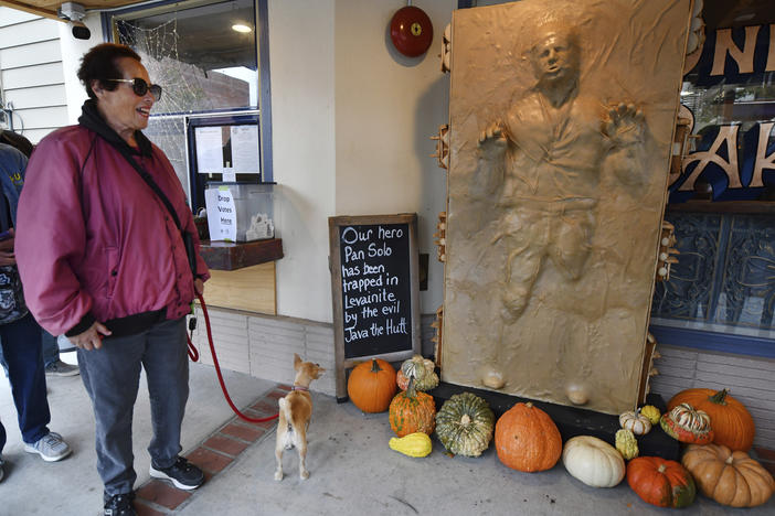 A customer and her dog enjoy a sculpture of "Star Wars" character Han Solo as he was frozen in carbonite made entirely of bread at the One House Bakery in Benicia, Calif.