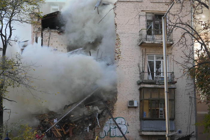 Firefighters work after a drone fired on buildings in Kyiv on Monday.