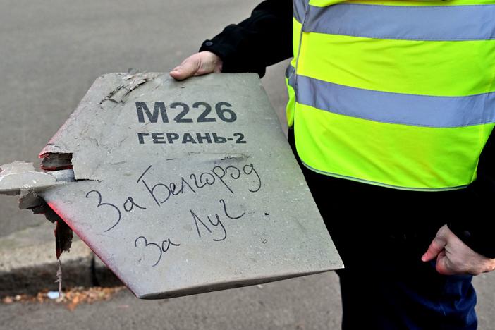 A police expert holds a fragment of a drone with a handwritten inscription reading "For Belgorod. For Luch" after a drone attack in Kyiv on Monday.
