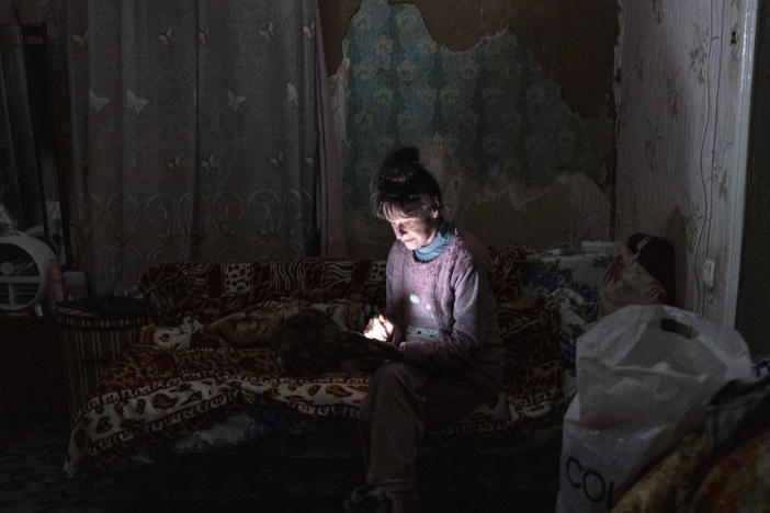Tetyana Safonova looks at her mobile phone during a power outage on Thursday in Borodyanka, Ukraine.