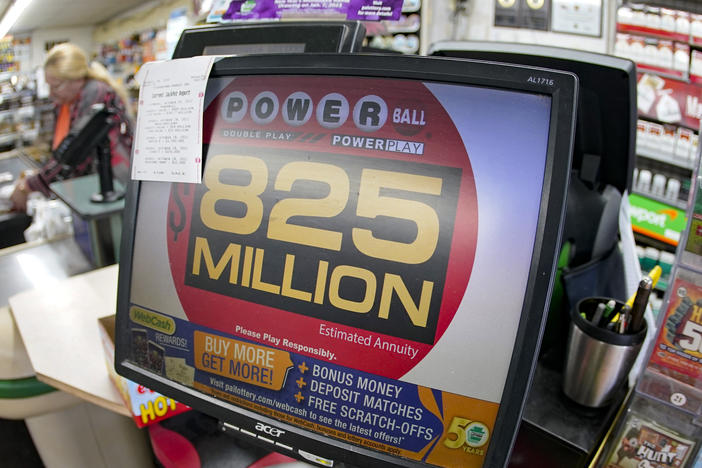 Customers pay for their groceries next to the lottery ticket display showing the jackpot amount for the Saturday, Oct. 29, drawing of the Powerball lottery at a market in Prospect, Pa., Friday, Oct. 28, 2022.