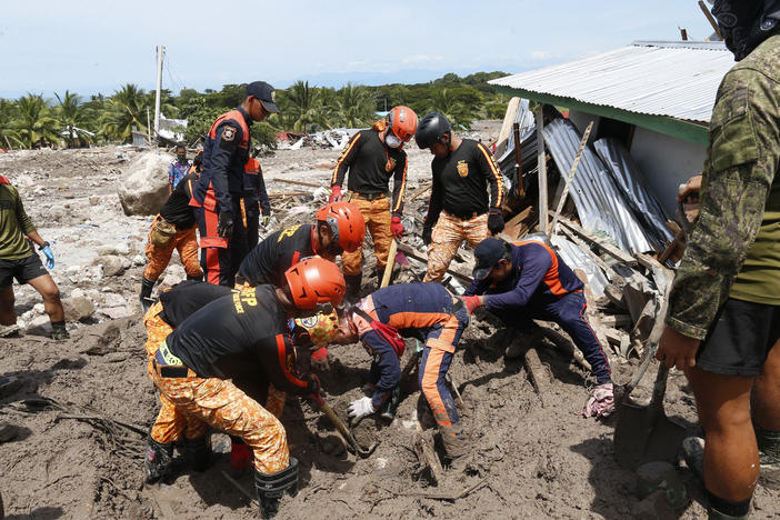 Rescuers work to retrieve a body at Maguindanao's Datu Odin Sinsuat town, southern Philippines on Sunday. Victims of a huge mudslide set off by Tropical Storm Nalgae in a coastal Philippine village that had once been devastated by a killer tsunami mistakenly thought a tidal wave was coming and ran to higher ground toward a mountain and were buried alive, an official said Sunday.