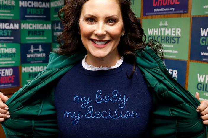 Michigan Gov. Gretchen Whitmer shows a "My Body My Decision" shirt at the 14th District Democratic Headquarters in Detroit on November 8.