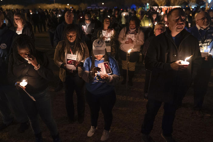 Community members, including Walmart employees, gather for a candlelight vigil at Chesapeake City Park in Chesapeake, Va., on Monday for the six people killed at a Walmart in Chesapeake, Va.