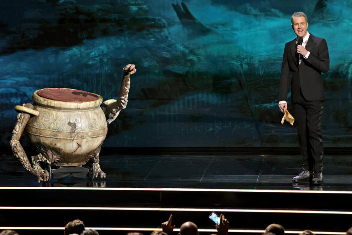 Geoff Keighley interacts with a "pot boy" from <em>Elden Ring</em> onstage during The Game Awards 2021.