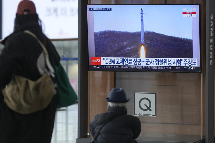 A TV screen shows a file image of North Korea's rocket with the test satellite during a news program at the Seoul Railway Station in Seoul, South Korea, on Saturday.