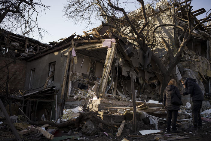 Serhii Kaharlytskyi, right, stands outside his home, destroyed after a Russian attack in Kyiv, Ukraine, Monday, Jan. 2, 2023. Kaharlytskyi's wife Iryna died in the attack on Dec. 31, 2022.