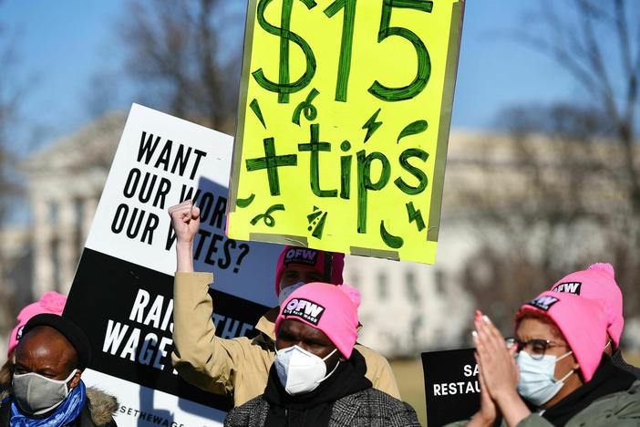 An activist holds a placard demanding a $15/hour minimum wage and tips for restaurant workers at the House Triangle of the U.S. Capitol in February.