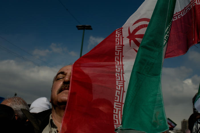 A man holds an Iranian flag during a parade in western Tehran.