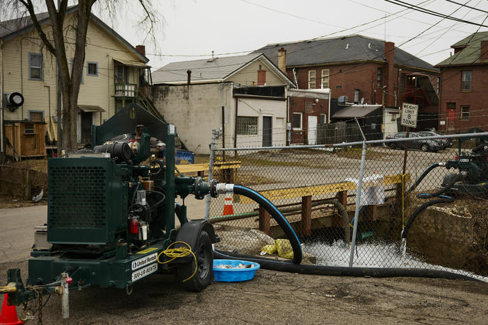 Water is pumped into a creek for aeration in East Palestine, Ohio, on Tuesday, more than a week after a train derailment released toxic chemicals.