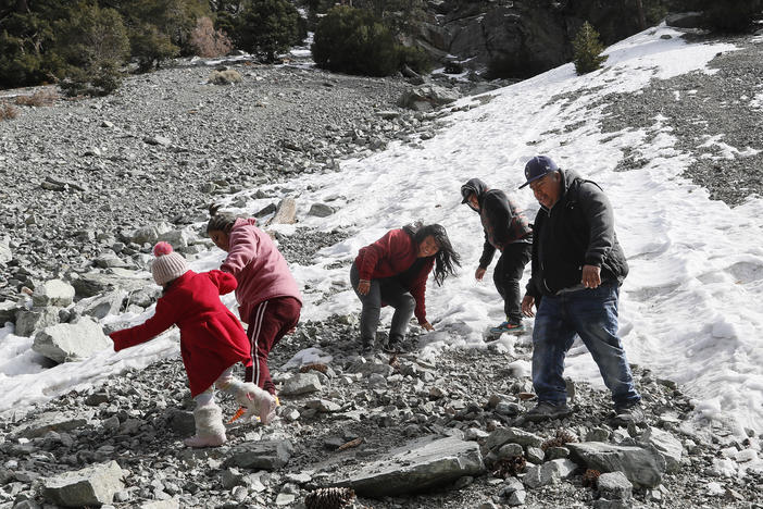 The Martinez Morales family frolic on a snowy roadside near Mt. Baldy, Calif. on February 16, 2023.
