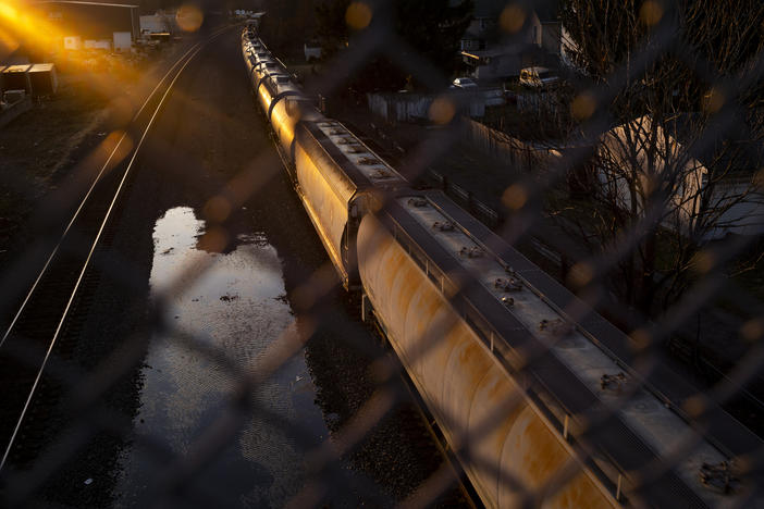 A Norfolk Southern train passes underneath a bridge in East Palestine, Ohio, several weeks after a derailment spilled hazardous chemicals into the area's soil and water.