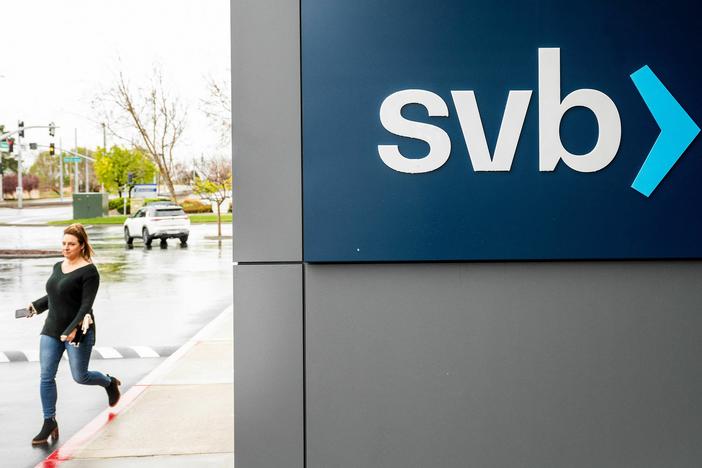A property manager representative passes a sign at Silicon Valley Banks headquarters in Santa Clara, California on March 10, 2023.