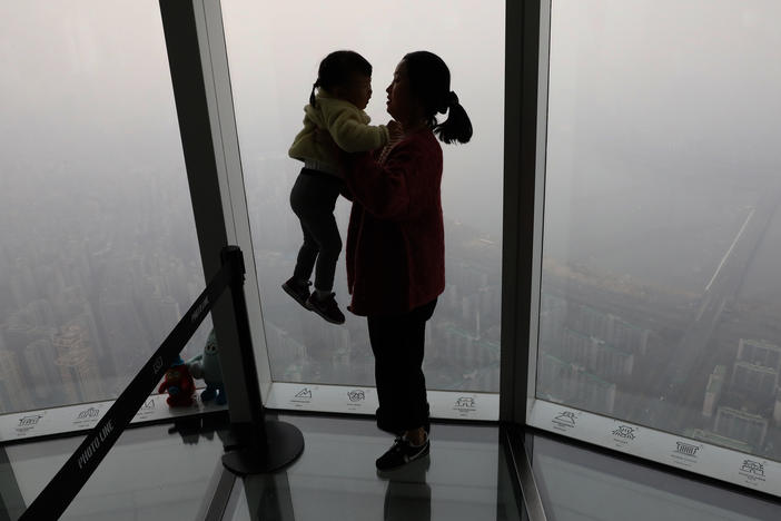 A woman holding her daughter looks at a view of Seoul in 2019. The fertility rate in South Korea, which has the world's lowest rate, hit 0.78 in February.