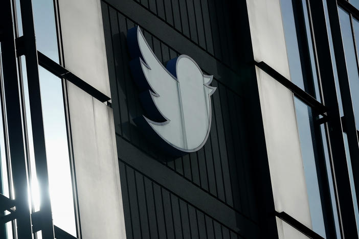 A Twitter logo hangs outside the company's offices in San Francisco, on Dec. 19, 2022.