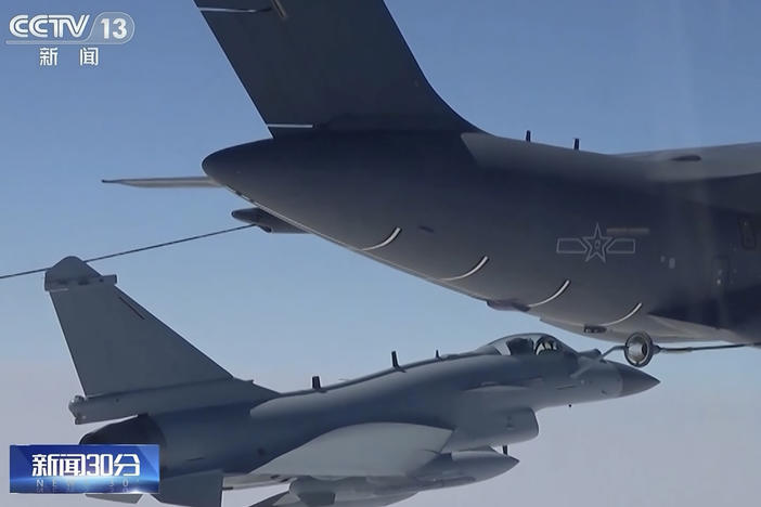 In this image taken from video footage run Saturday by China's CCTV, a Chinese fighter jet performs an mid-air refueling maneuver at an unspecified location.