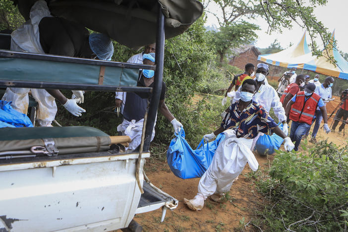 Police and local residents load the exhumed bodies of victims of a religious cult into the back of a truck in the village of Shakahola, near the coastal city of Malindi, in southeastern Kenya on Sunday.