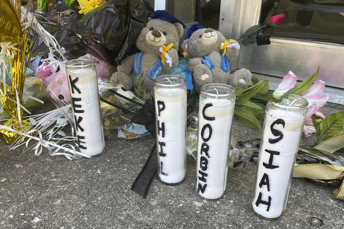 Candles with the names of the four young people killed in a shooting and teddy bears dressed in graduation caps sit outside the Mahogany Masterpiece dance studio on Wednesday, April 19, 2023, in Dadeville, Ala.