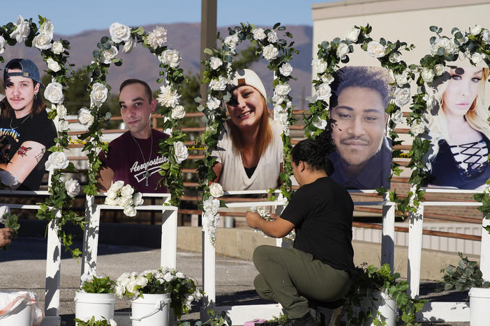 Noah Reich, left, and David Maldonado, the Los Angeles co-founders of Classroom of Compassion, put up a memorial Nov. 22, 2022, with photographs of the five victims of a weekend mass shooting at a nearby gay nightclub in Colorado Springs, Colo.