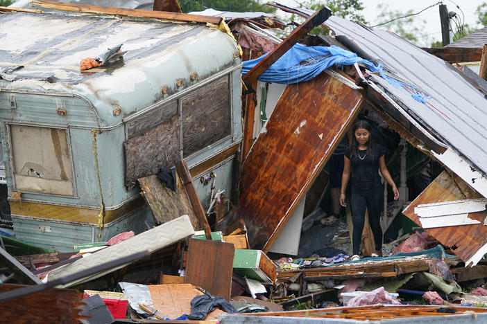 A person stands outside of a damaged home after a tornado hit Saturday, in the unincorporated community of Laguna Heights, Texas, near South Padre Island.