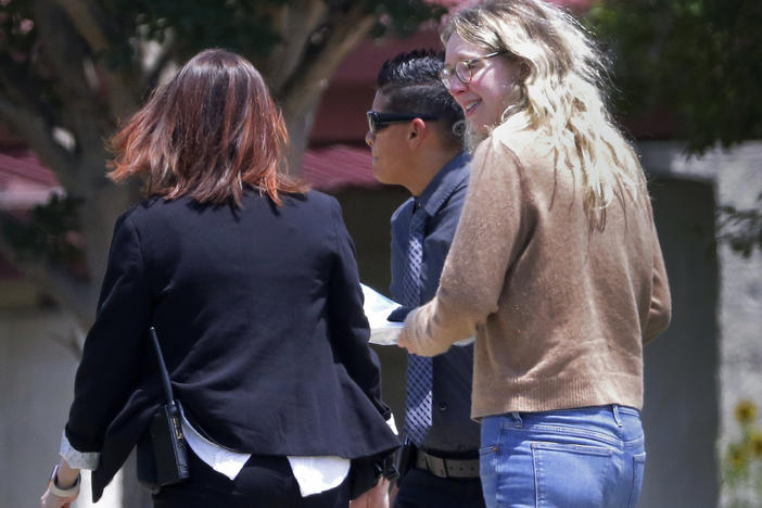 Disgraced Theranos CEO Elizabeth Holmes is escorted by prison officials into a federal women's prison camp in Bryan, Texas.