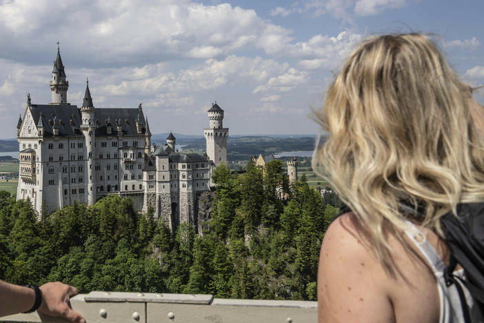 People watch the Neuschwanstein castle, in Schwangau, Germany, Thursday, June 15, 2023.