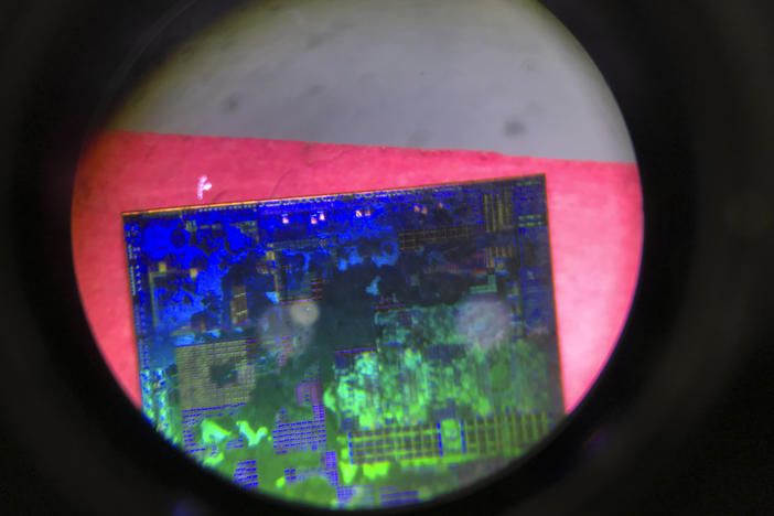 A Chinese microchip is seen through a microscope at the 21st China Beijing International High-tech Expo in Beijing, China, in 2018. China has imposed export curbs on two metals used in computer chips and solar cells, expanding a trade squabble with Washington.