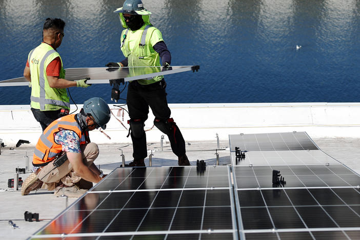Workers install solar panels at the Port of Los Angeles in California.