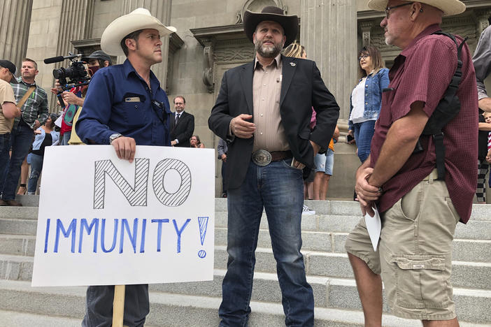 Ammon Bundy, center, who led a protest at a Boise hospital last year, stands on the Idaho Statehouse steps in Boise, Idaho, on Monday, Aug. 24, 2020.