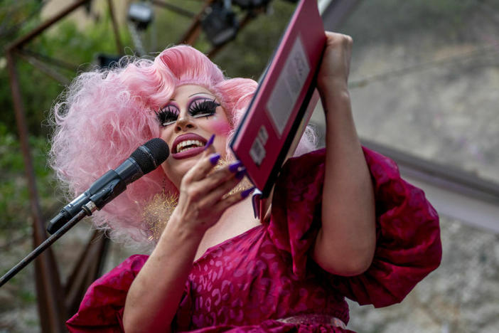 Drag Queen Brigitte Bandit reads a book during a story time reading at the Cheer Up Charlies dive bar on March 11, 2023 in Austin, Texas. Bills to restrict drag performances across the country have failed to make an impact.