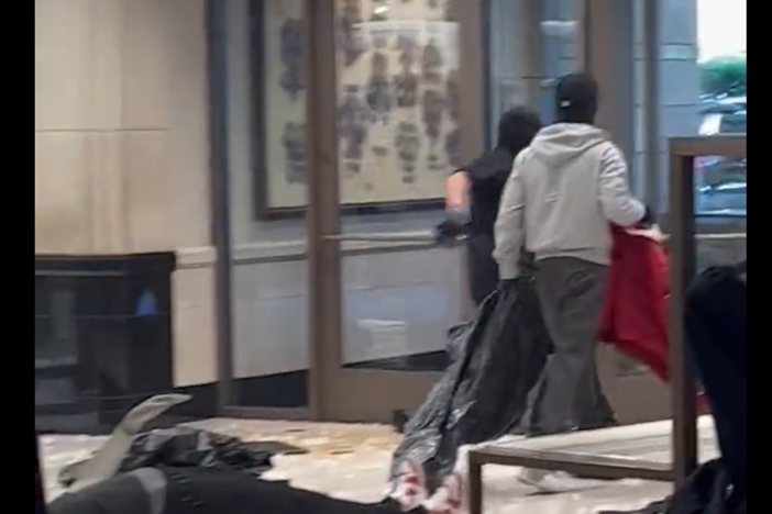 A screenshot of video posted by @noelskeez on X, formerly known as Twitter, shows masked robbers ransacking the department store in Topanga, Calif.