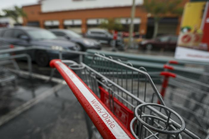 A Winn Dixie shopping cart is seen in the parking lot of the Palm Harbor, Fla., store on Wednesday, Aug. 16, 2023.