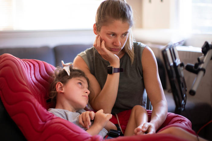 Jenny Eckart Hoyt directs her daughter Winnie's attention to an "eye gaze" device in their Portland, Ore., home.