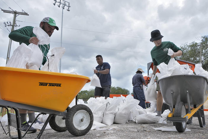 Members of the Tampa, Fla., Parks and Recreation Department help residents with sandbags on Monday, Aug. 28, 2023. Residents along Florida's gulf coast are making preparations for the effects of Tropical Storm Idalia.