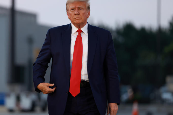 Former President Donald Trump arrives at Atlanta Hartsfield-Jackson International Airport after being booked at the Fulton County jail on Aug. 24.