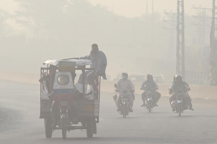 Commuters make their way down a smoggy road in Lahore, Pakistan in 2022. Extreme heat waves make air pollution, like smog, worse.