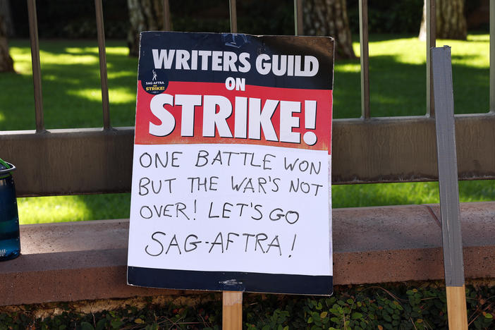 A WGA support sign rests near SAG-AFTRA members picketing outside Warner Bros. Studio as the actors strike continues on September 26, 2023 in Burbank, California.