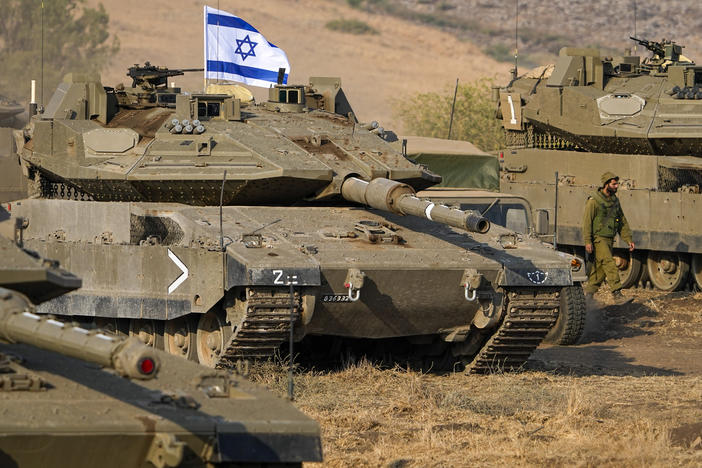 Israeli tanks are stationed near the border with Lebanon on Wednesday. A plurality of Americans say Israel's response to a deadly attack by Hamas has been about right.