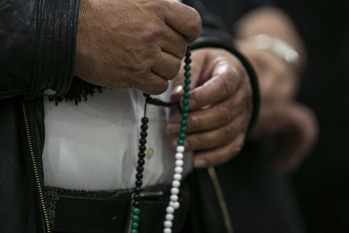 A person identified as a family member of the slain 6-year-old boy holds prayer beads at a news conference at the Muslim Community Center on Chicago's northwest side on Sunday.