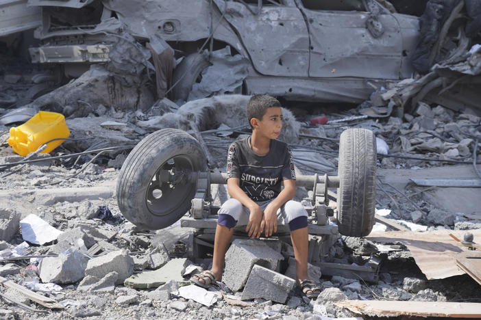 A Palestinian boy sits on the rubble of his building destroyed in an Israeli airstrike in Nuseirat camp in the central Gaza Strip on Monday.