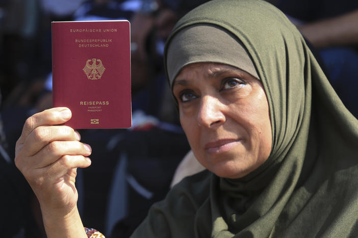 A Palestinian-German woman shows her German passport at the Rafah border crossing between the Gaza Strip and Egypt on Saturday. The crossing point remains closed, but is a potential route for foreign passport holders to leave Gaza, and for humanitarian supplies to enter as the Mideast crisis worsens.