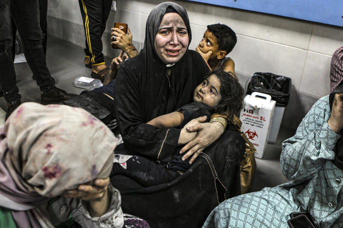 Wounded Palestinians sit in al-Shifa hospital in Gaza City, central Gaza Strip, after arriving from Al-Ahli hospital following an explosion there, on Tuesday.