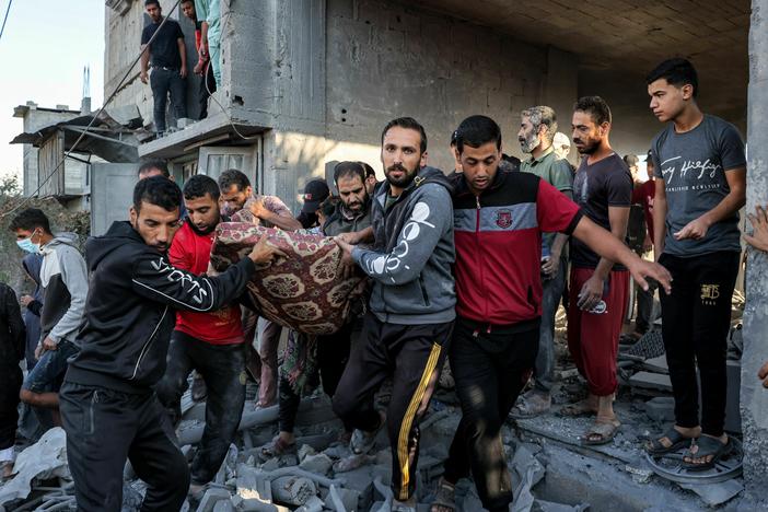 Men carry out the body of a victim from a building in Rafah in the southern of Gaza Strip as the Israeli bombardment continued Thursday.