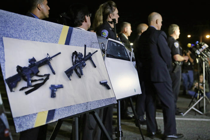 Police crime photos of assault rifles and handguns are displayed during a news conference near the site of a mass shooting in San Bernardino, Calif., on Dec. 3, 2015.