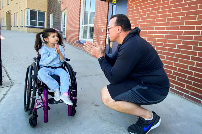 John Opp and his daughter Giuliana communicate with their hands at the Isabella Bird Community School in Denver. Opp said he's grateful for the universal pre-K program and the support it provides her.