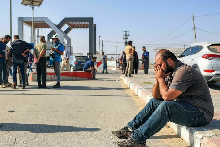 A man reacts as he sits near the gate to the Rafah border crossing with Egypt in the south of the Gaza Strip on November 3, 2023.